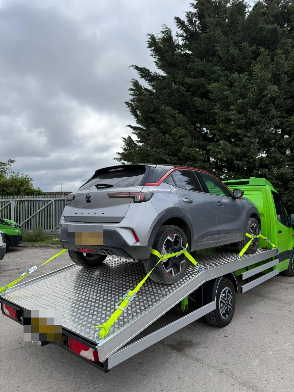 A grey SUV secured with ratchet straps on Toma Recovery's flatbed